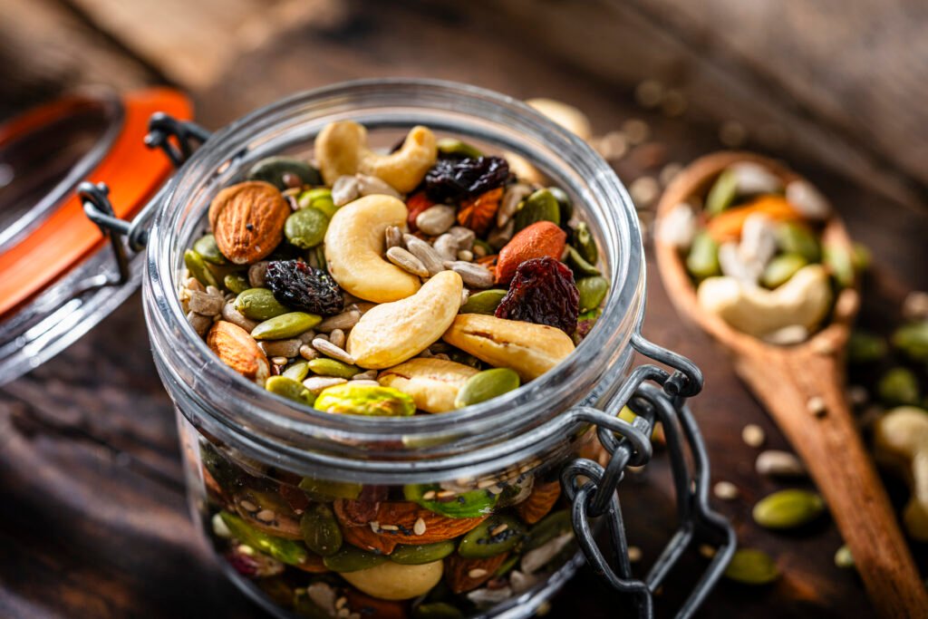 Variety of trail mix and nuts in portion-controlled packages for emergency kits Close up of a glass container filled with organic mix of nuts and seeds